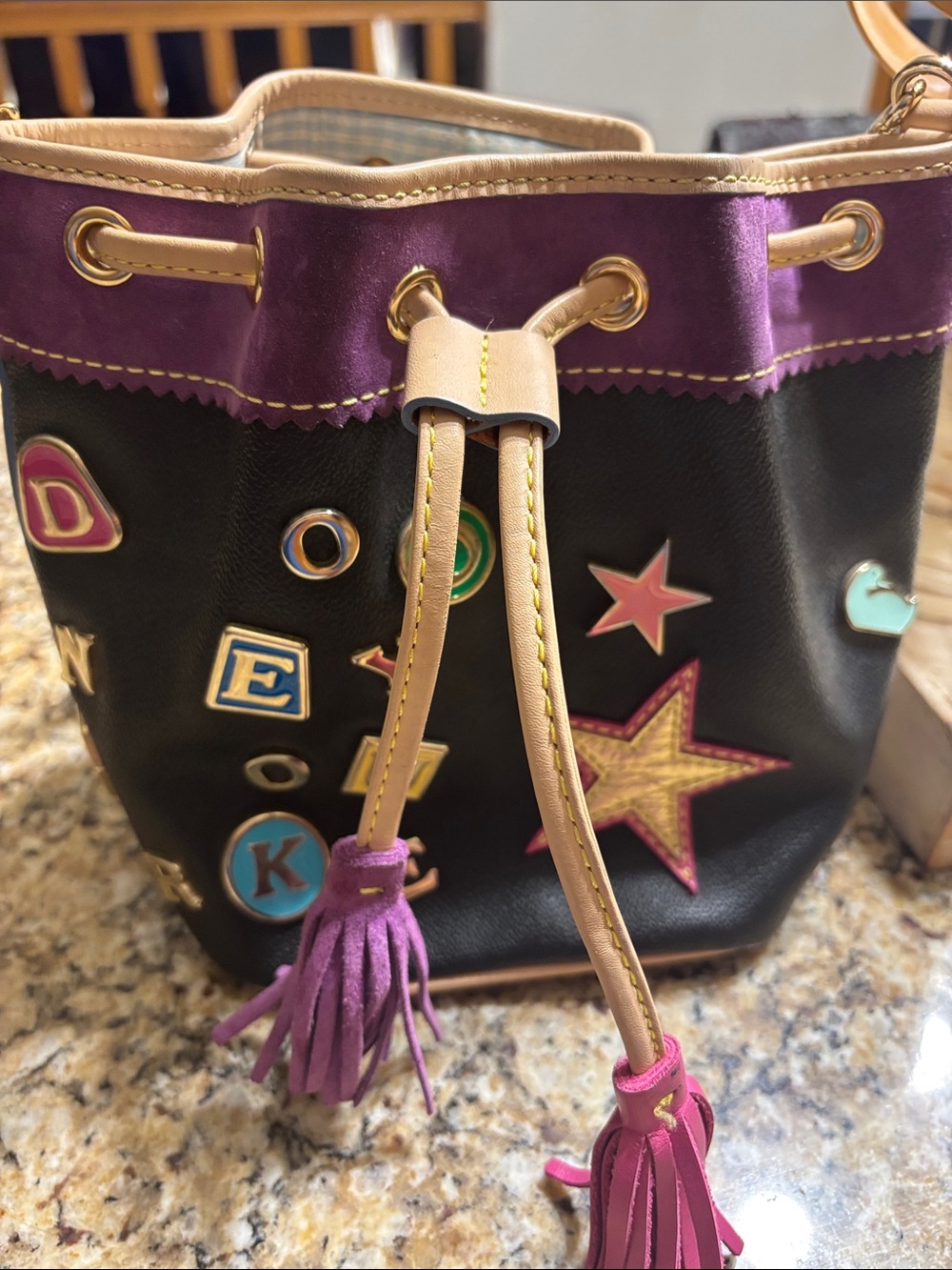 Black & Purple Drawstring Bucket Bag with Tassel Accents has some stains.
